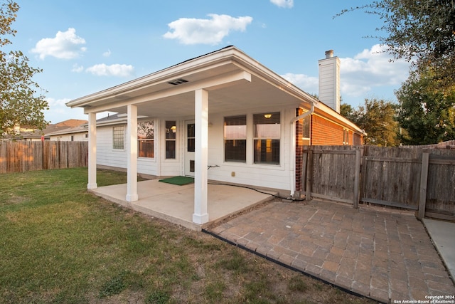 rear view of property featuring a patio area and a yard