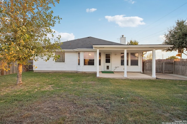 rear view of property featuring a yard and a patio area