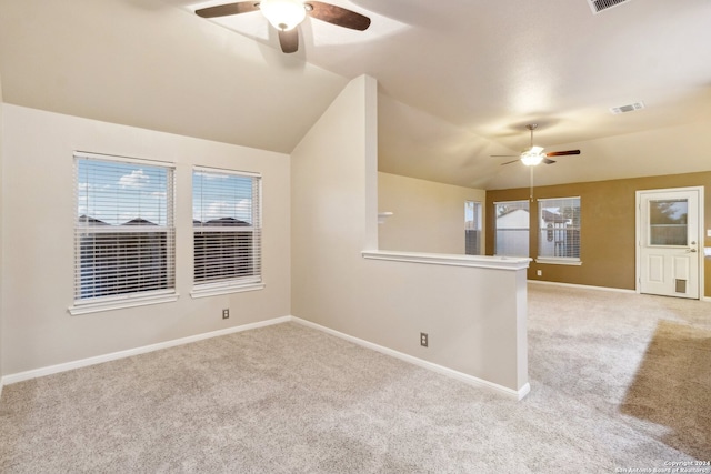 empty room featuring ceiling fan, light carpet, and vaulted ceiling