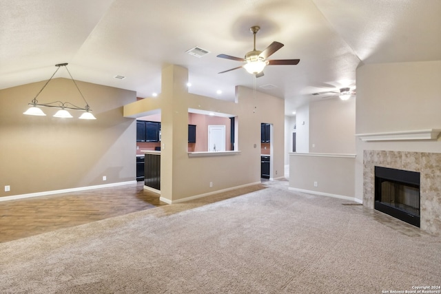 unfurnished living room featuring ceiling fan, carpet floors, a fireplace, and vaulted ceiling