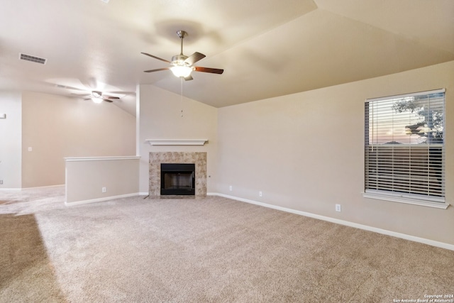 unfurnished living room featuring carpet, ceiling fan, lofted ceiling, and a tiled fireplace