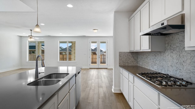 kitchen with hardwood / wood-style floors, white cabinets, appliances with stainless steel finishes, and sink