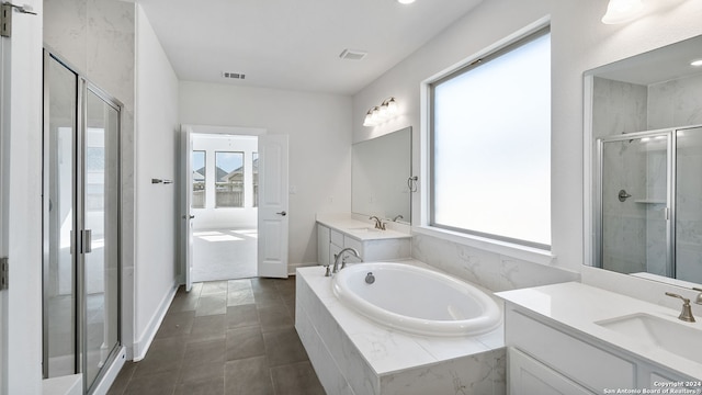 bathroom with a healthy amount of sunlight, vanity, and independent shower and bath