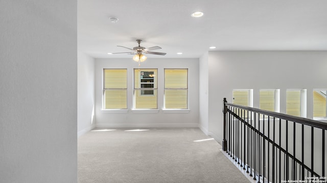 corridor with light colored carpet and a healthy amount of sunlight