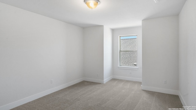 unfurnished room featuring light colored carpet