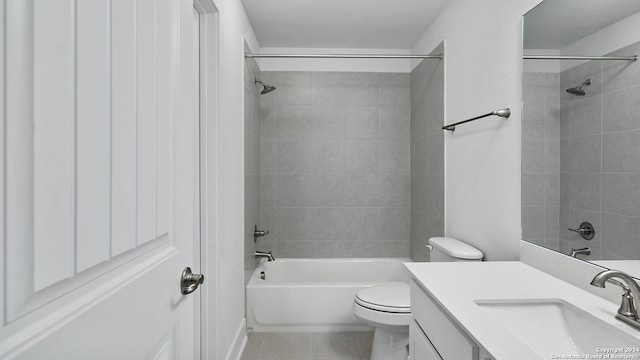 full bathroom featuring tile patterned floors, vanity, toilet, and tiled shower / bath combo