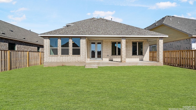 rear view of property featuring a patio and a lawn