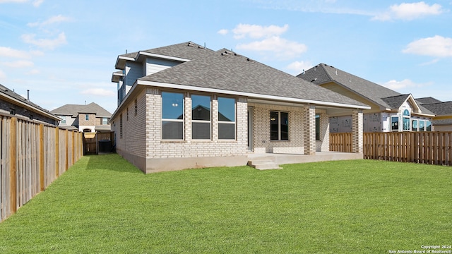 back of property with a lawn and a patio area