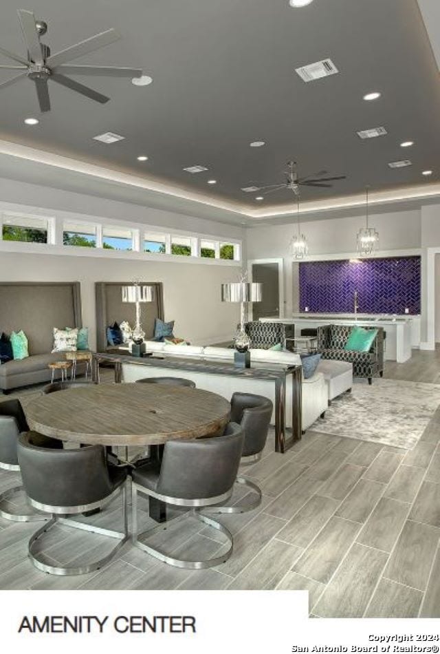 interior space featuring ceiling fan with notable chandelier and light hardwood / wood-style flooring