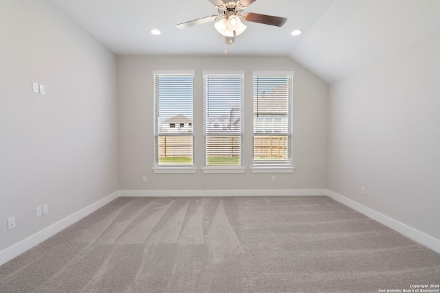 carpeted spare room featuring ceiling fan and vaulted ceiling