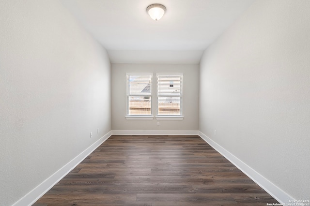 unfurnished room with lofted ceiling and dark hardwood / wood-style floors