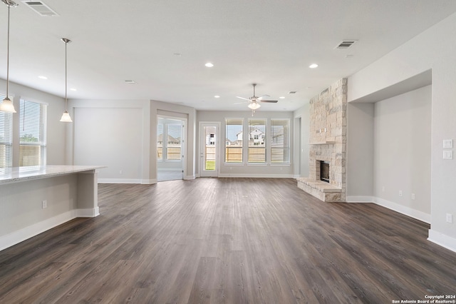 unfurnished living room with a fireplace, ceiling fan, and dark hardwood / wood-style floors