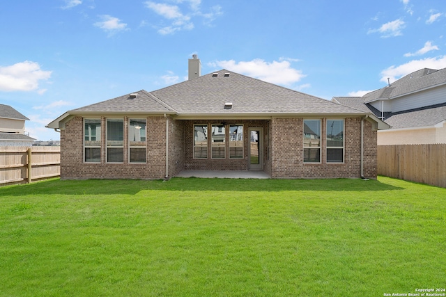 rear view of property featuring a patio and a yard