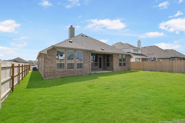 rear view of house with a lawn and a patio