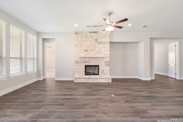 unfurnished living room featuring a fireplace, dark hardwood / wood-style floors, and ceiling fan