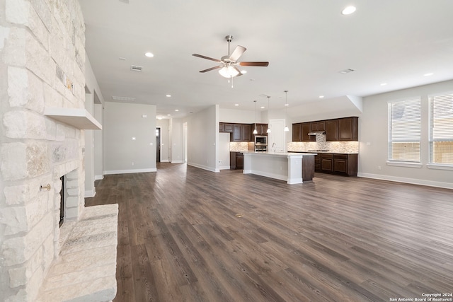 unfurnished living room featuring a fireplace, ceiling fan, dark wood-type flooring, and sink