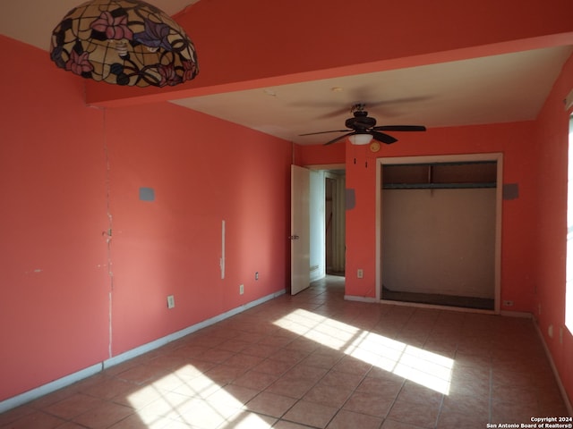 unfurnished bedroom featuring light tile patterned flooring, a closet, and ceiling fan