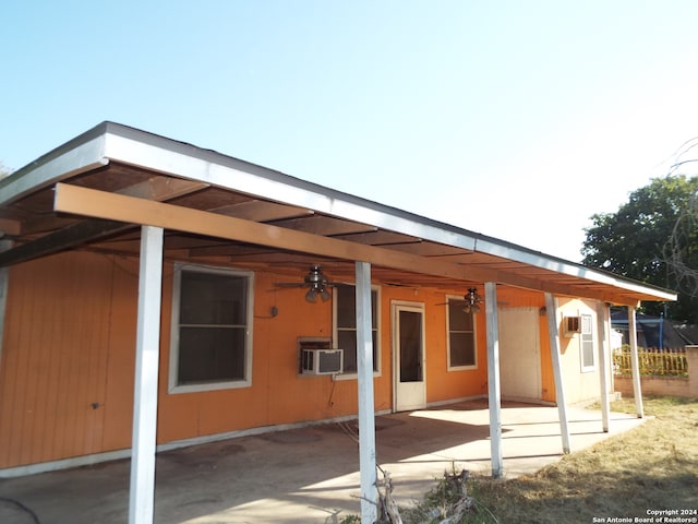 back of property with an AC wall unit, cooling unit, ceiling fan, and a patio