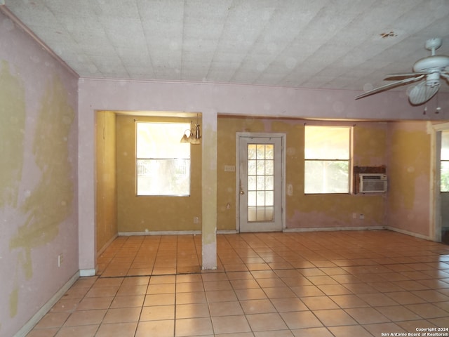 tiled empty room with ceiling fan and a wall mounted AC