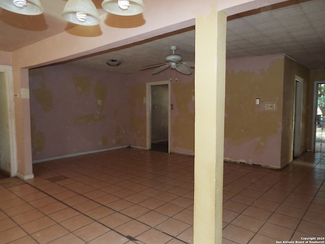 tiled empty room featuring ceiling fan