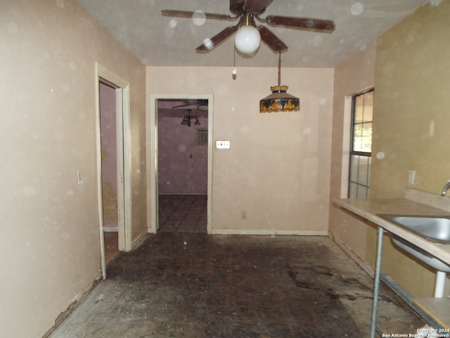 unfurnished dining area featuring ceiling fan and sink