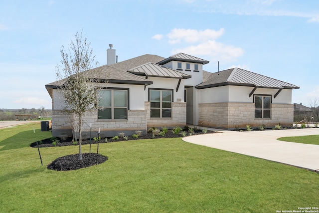 prairie-style home with a front lawn and central air condition unit