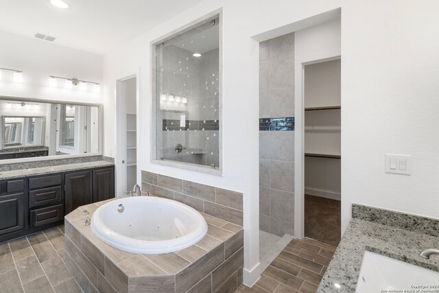 bathroom with independent shower and bath and vanity