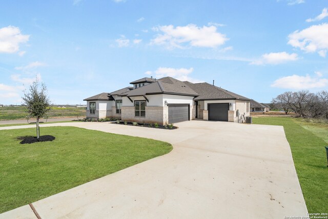 prairie-style home featuring a front lawn and a garage