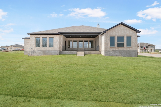 rear view of property featuring a lawn