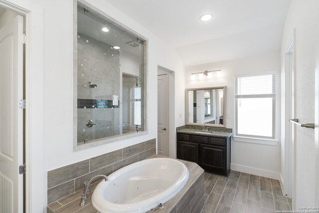 bathroom with separate shower and tub, vanity, and wood-type flooring