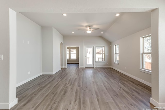 unfurnished living room featuring lofted ceiling, ceiling fan, and light wood-type flooring