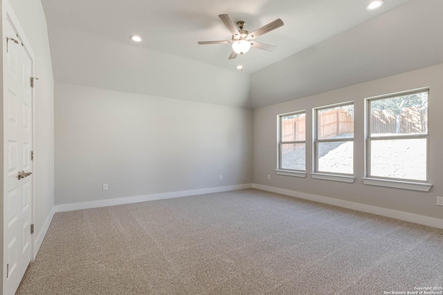 carpeted empty room featuring vaulted ceiling and ceiling fan