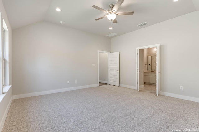 unfurnished bedroom with vaulted ceiling, light colored carpet, ceiling fan, and ensuite bath