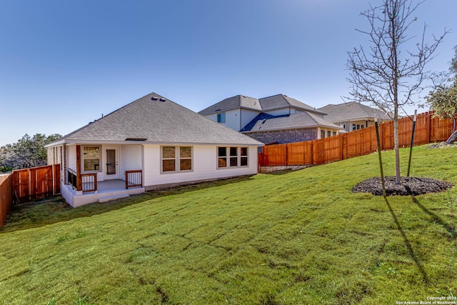 rear view of property with a patio and a lawn