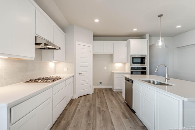 kitchen with sink, white cabinetry, a center island with sink, appliances with stainless steel finishes, and pendant lighting