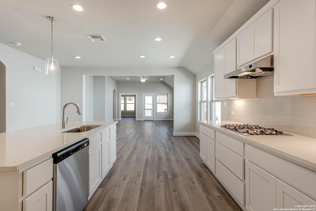 kitchen featuring sink, appliances with stainless steel finishes, white cabinetry, light hardwood / wood-style floors, and decorative light fixtures