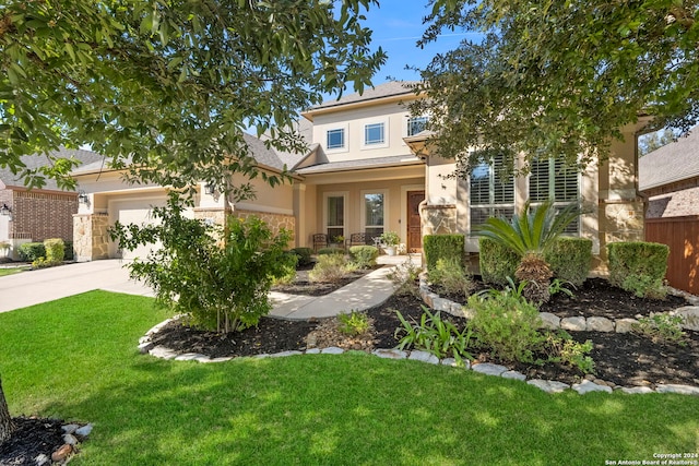 view of front of property featuring a porch, a front lawn, and a garage