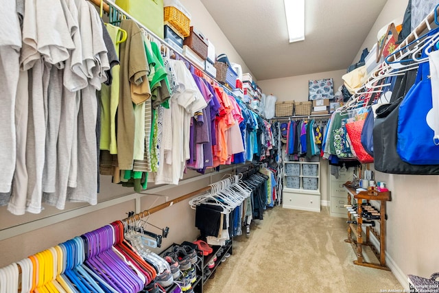 walk in closet featuring light carpet