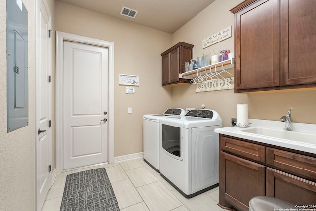 washroom with cabinets, electric panel, light tile patterned floors, sink, and washer and clothes dryer