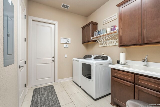 laundry room with washer and dryer, cabinet space, a sink, visible vents, and electric panel