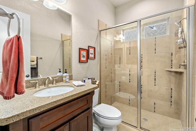 full bathroom with toilet, a textured wall, a shower stall, and vanity