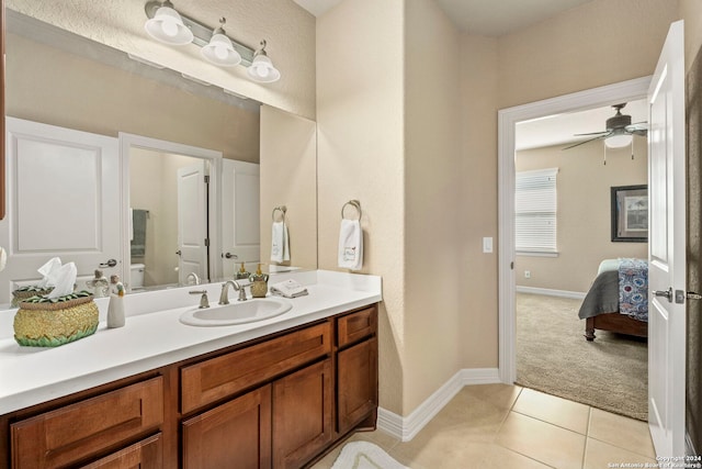 ensuite bathroom with tile patterned flooring, vanity, ensuite bathroom, baseboards, and ceiling fan