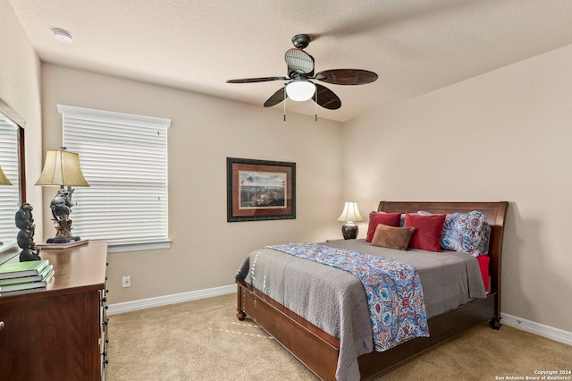 carpeted bedroom featuring a textured ceiling and ceiling fan