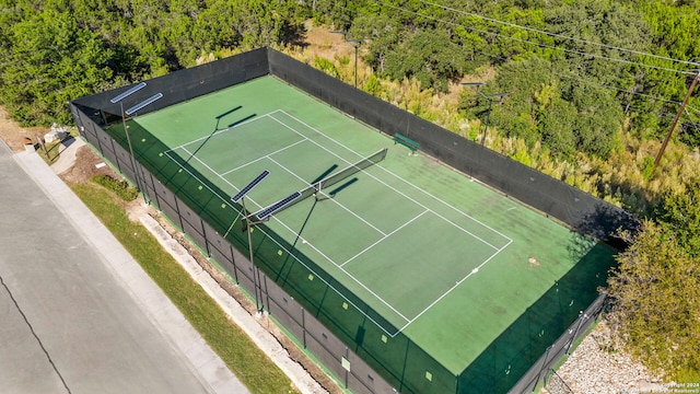 view of sport court with a view of trees and fence