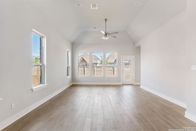 spare room featuring light hardwood / wood-style floors, vaulted ceiling, and ceiling fan