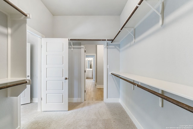 spacious closet featuring light carpet