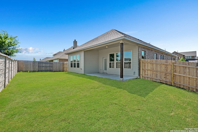 back of property featuring a lawn and a patio