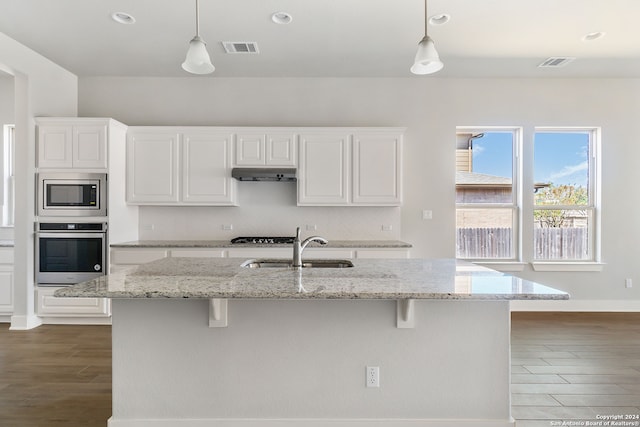 kitchen with stainless steel appliances, light stone countertops, dark hardwood / wood-style flooring, and white cabinetry