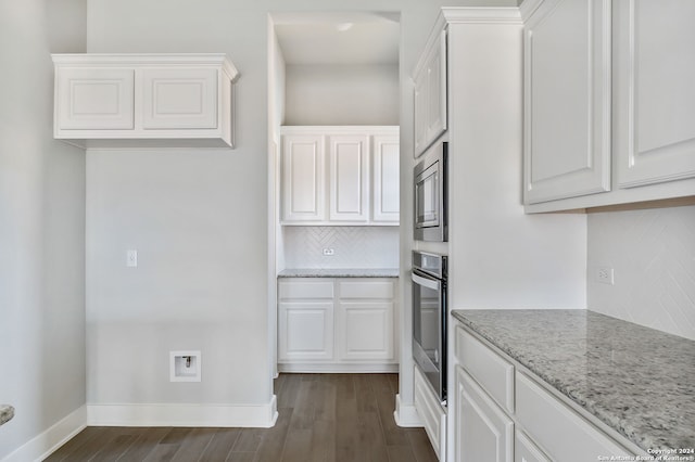 kitchen featuring light stone countertops, stainless steel appliances, and white cabinetry