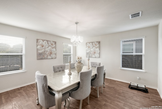 dining space featuring hardwood / wood-style flooring and a notable chandelier